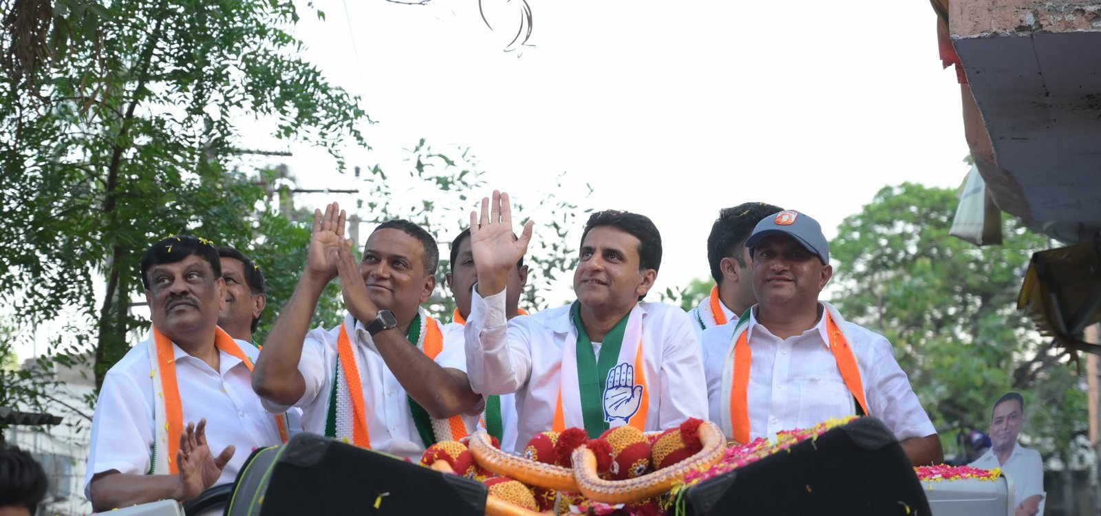 Mansoor Ali Khan with party colleagues on a roadshow through a Bengaluru street at golden hour.